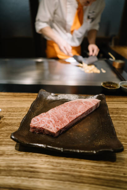 istock A piece of marbled beef on a plate with chef working in the background 1156206397