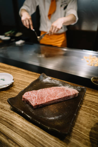 istock A piece of marbled beef on a plate with chef working in the background 1156206410