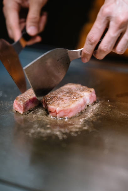 istock Chef cooking a piece of marbled beef on a grilling surface 1156206455