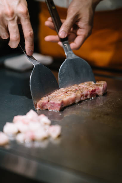 istock Chef cooking pieces of marbled beef on a grilling surface 1156206484