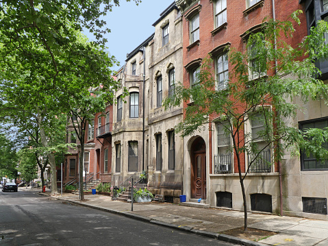 old urban neighborhood, shady street with townhouses