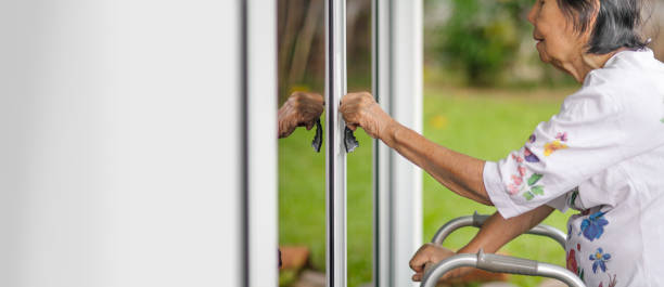 istock Elderly woman with key opening front door. 1156208396