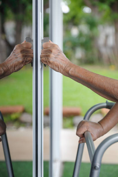 istock Elderly woman with key opening front door. 1156208401