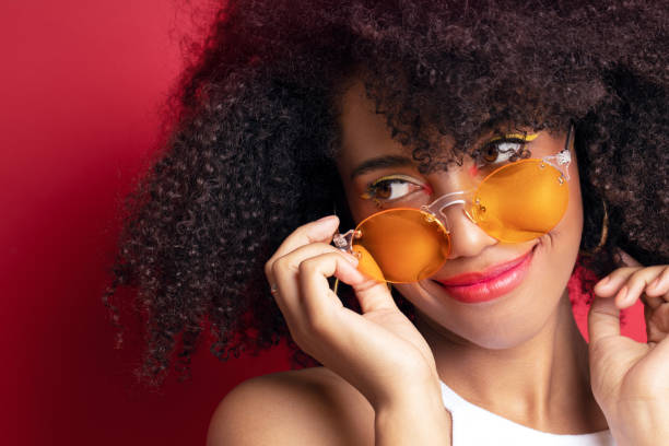 istock model with dark curly hair in orange glasses 1156209281
