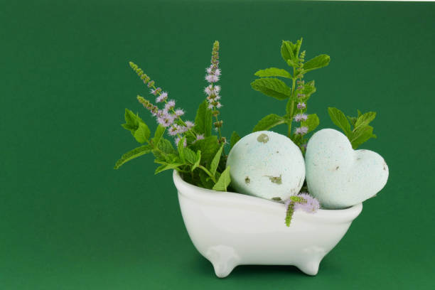 istock mint bath bombs.green bombs for the bath with mint extract, sprigs of fresh blooming mint in a ceramic white bath on a dark green background. 1156210908