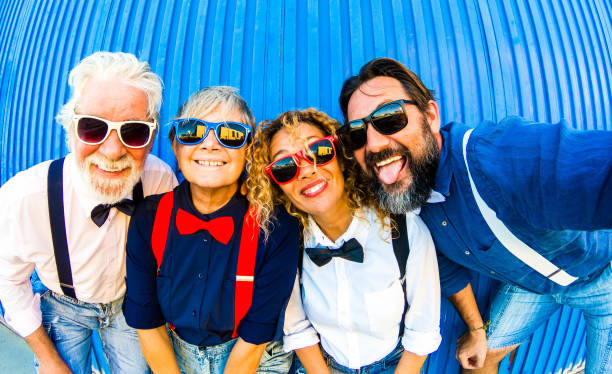 istock Smiles and funny faces for two caucasian couplew. Taking a selfie in front to a blue wall. Emotions and colors. Two generations family together in happiness. 1156212708