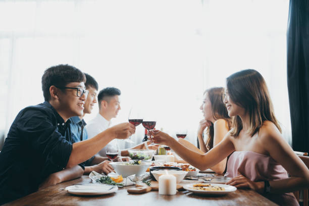grupp av glada unga asiatiska man och kvinna chattar, ha roligt och rostning med rött vin under fest - speed dating bildbanksfoton och bilder