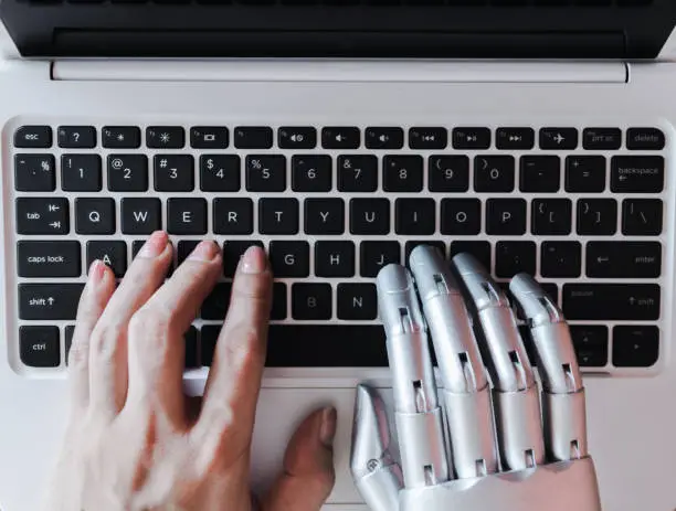 Photo of Robot hands and fingers point to laptop button advisor chatbot robotic artificial intelligence concept