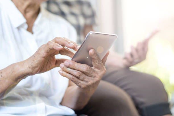 heureux personnes âgées personnes âgées style de vie concept de la technologie. les femmes vieillissantes d'asie utilisant le smartphone de tablette ou le téléphone portable partagent les médias sociaux ensemble dans la maison de comté de bien-êtr - ipad women human hand digital tablet photos et images de collection