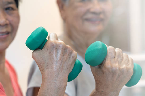 istock Strong and healthy senior old people holding  dumbbells for doing exercise or physical therapy in nursing home. 1156216378