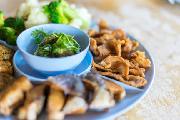 タイ北部のグリーンチリディップ(ナムプリクナム)は、カリカリの割れ目とゆで野菜を添えたストリーキーポークを添えました。 - meat dusk cauliflower food ストックフォトと画像