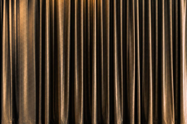 istock golden closed stage curtain with light effect 1156217686