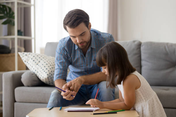 istock Cute girl have fun drawing picture with dad 1156224830