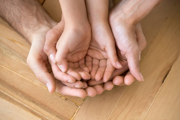 primo piano di amare mamma papà e bambino tenere le mani sul pavimento palmi - multi generation family adoption family human hand foto e immagini stock