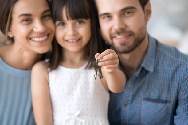 Excited young family with kid hold keys become homeowners Close up of happy young family with preschooler child hold keys moving to new apartment together, excited millennial parents with little daughter buy first own home. Ownership, relocation concept happy family with key of their new house stock pictures, royalty-free photos & images