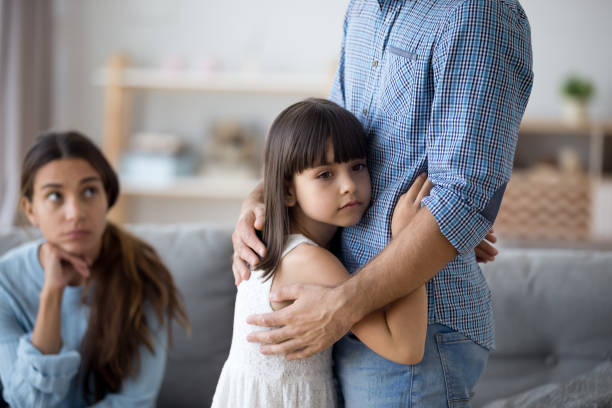 Unhappy little child hug leaving parent say goodbye Sad little girl hug father upset by father leaving on business trip, unhappy young family in living room with preschooler daughter embrace say goodbye to father, parents divorce hurt small child divorce children photos stock pictures, royalty-free photos & images