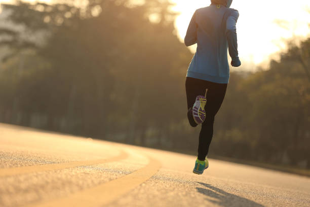 giovane fitness donna runner che corre sulla strada dell'alba - autumn jogging outdoors running foto e immagini stock