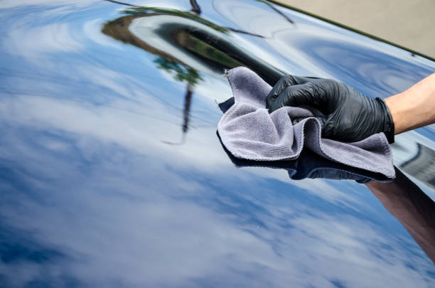 detal samochodu - mężczyzna trzyma mikrofibry w ręku i poleruje samochód. - protective varnish zdjęcia i obrazy z banku zdjęć