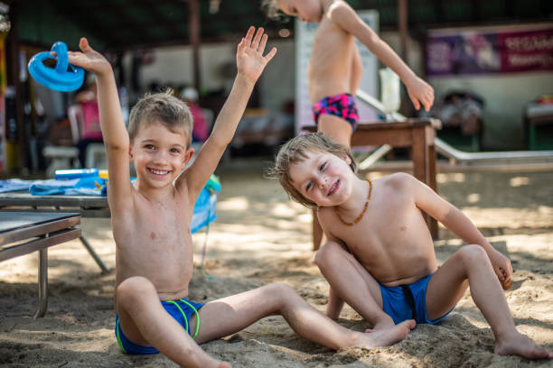 istock Happy boys playing in sand on the beach 1156235073