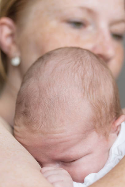 istock Newborn boy is sleeping in arms 1156236091