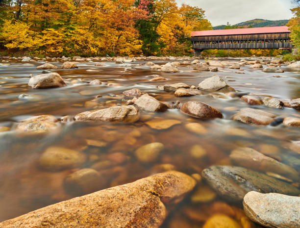 istock Swift River and old covered bridge at autumn 1156236241