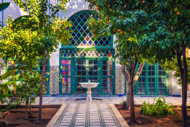 piccola fontaine bianca tra gli aranci di jardin majorelle, marrakech, marocco - blossom orange orange tree citrus fruit foto e immagini stock