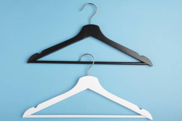 istock Black and white hangers interlocked with each other on blue background. Concept view. 1156238068