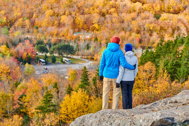 Couple hiking at Artist's Bluff in autumn Couple hiking at Artist's Bluff in autumn. Fall colours in Franconia Notch State Park. White Mountain National Forest, New Hampshire, USA franconia new hampshire stock pictures, royalty-free photos & images