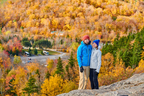 Couple hiking at Artist's Bluff in autumn Couple hiking at Artist's Bluff in autumn. Fall colours in Franconia Notch State Park. White Mountain National Forest, New Hampshire, USA franconia new hampshire stock pictures, royalty-free photos & images