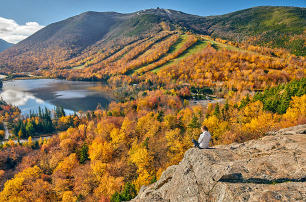 Woman hiking at Artist's Bluff in autumn Woman hiking at Artist's Bluff in autumn. View of Echo Lake. Fall colours in Franconia Notch State Park. White Mountain National Forest, New Hampshire, USA franconia new hampshire stock pictures, royalty-free photos & images