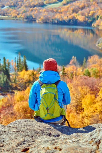 Backpacker man at Artist's Bluff in autumn Backpacker man hiking at Artist's Bluff in autumn. View of Echo Lake. Fall colours in Franconia Notch State Park. White Mountain National Forest, New Hampshire, USA franconia stock pictures, royalty-free photos & images