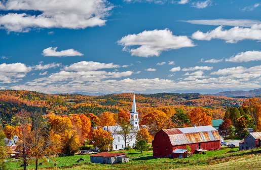 Congregational Church and farm with red barn at sunny autumn day in Peacham, Vermont, USA