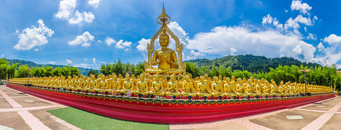 Panorama of Big golden Buddha statue among small 1,250 Buddha statue at Makha Bucha Buddhist memorial park built on the occasion of Great period, Buddha 2600 years at nakhon nayok province, Thailand