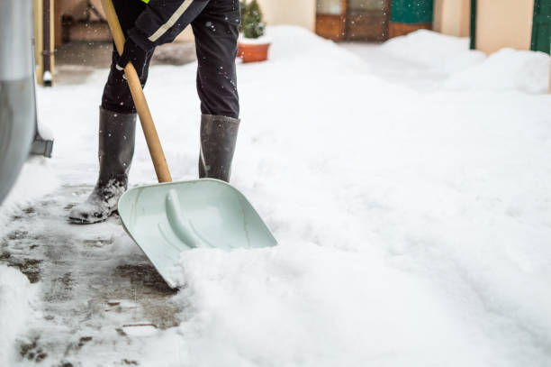 istock Man with snow shovel cleans sidewalk 1156241499