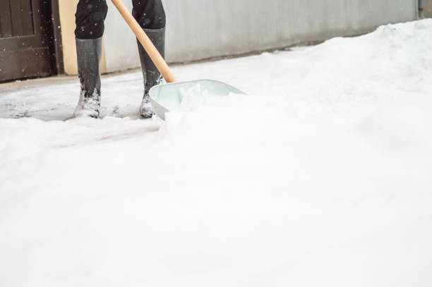 istock Man with snow shovel cleans sidewalk 1156241627