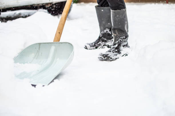 istock Man with snow shovel cleans sidewalk 1156241741