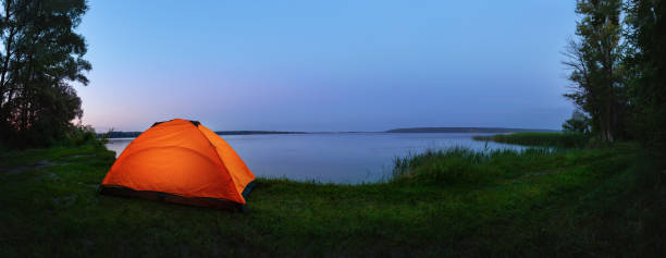 istock Orange tent by the lake 1156245418