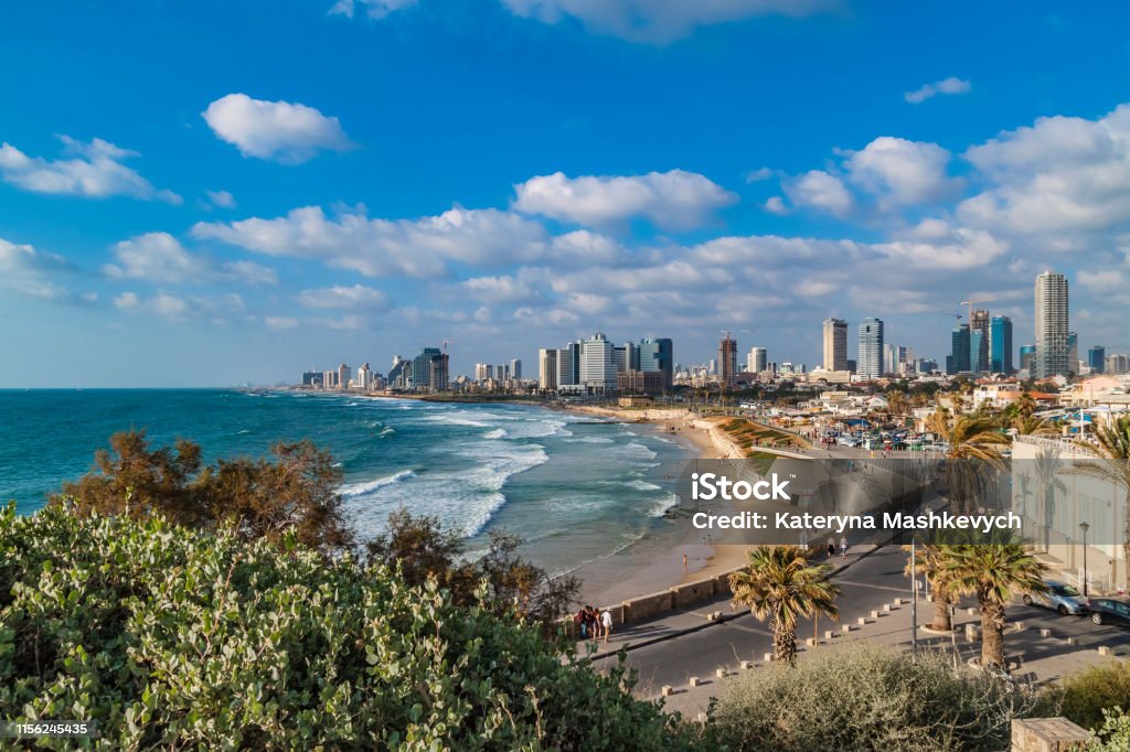 Panoramic view of modern Tel Aviv sky line and beach on sunny day. Mediterranean sea, Israel. Sea waves and cloudy sky. Tel Aviv Stock Photo