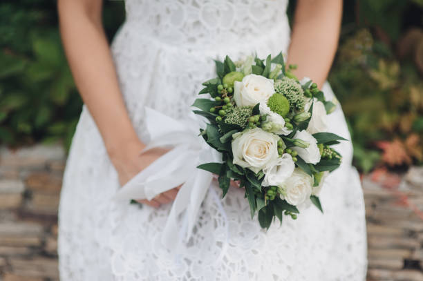 istock Wedding bouquet in bride's hands. White roses. Flowers for lady. 1156247103