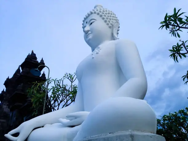 Big White Meditating Buddha Statue Bottom Side View In The Front Of The Garden Yard Of Buddhist Temple, North Bali, Indonesia