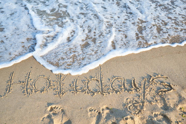 istock holiday word is written on the beach sand 1156251236