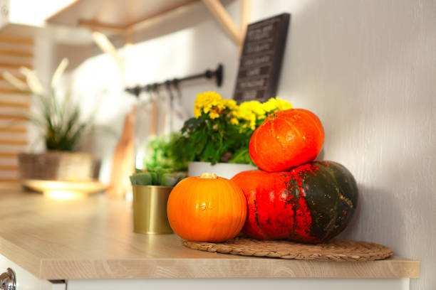Detail little white modern kitchen with pumpkins on the wood worktop