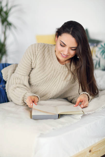istock Young happy brunette woman with book 1156258386