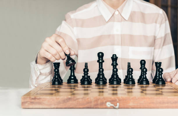 istock Wooden chess pieces on a chessboard, chess game woman player makes a move 1156259701