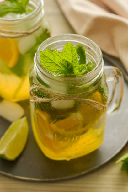 istock Homemade lemonade with lime, mint in a mason jar on a wooden rustic table. Summer drinks. 1156261181