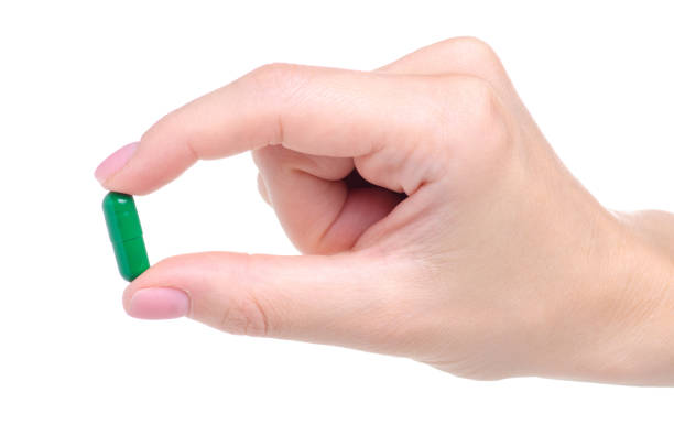 istock Green pills capcule medicine pharmasy in hand 1156266756