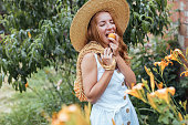 Young  woman eating apricot  in garden