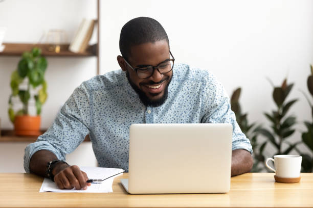 istock Head shot smiling african-american manager using laptop looking at screen 1156269801