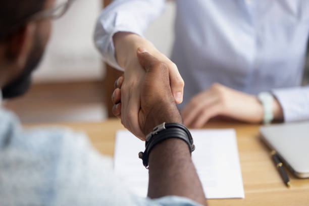 feche acima das mãos do aperto de mão da vista após a entrevista e a negociação bem sucedidas - financial occupation business shaking human hand - fotografias e filmes do acervo