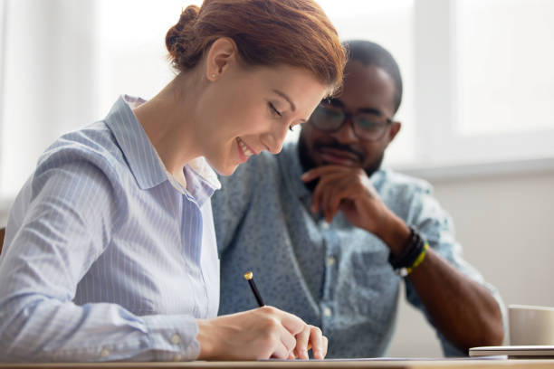 istock Young female candidate signing contract after successful interview in office 1156269846